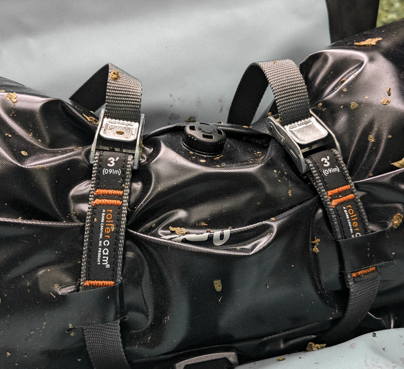 Black duffel bag secured with Rollercam 3/4" 3ft straps on a gray background