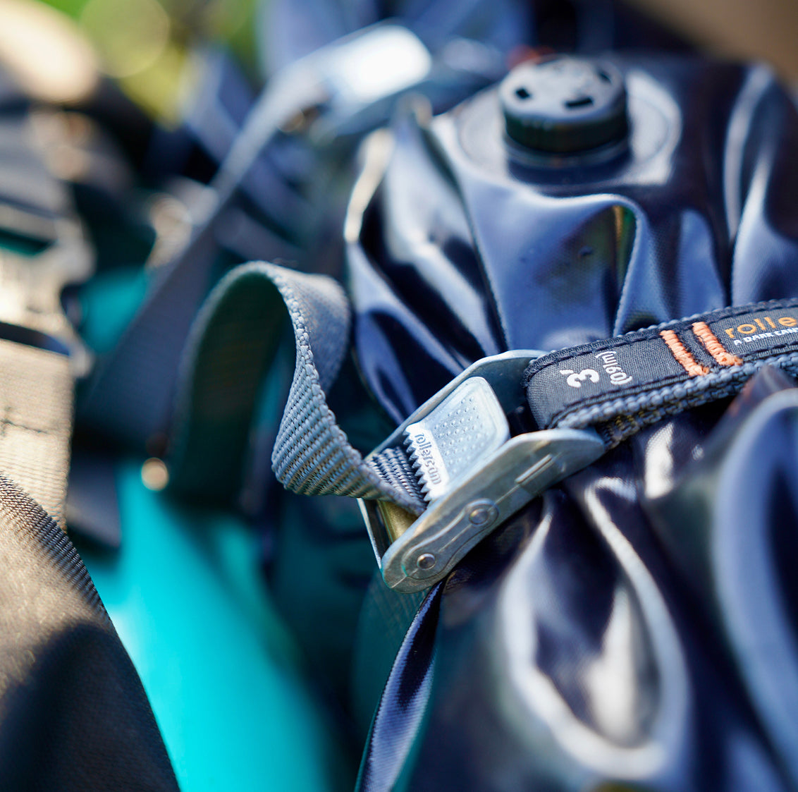 Close-up of a dark blue waterproof pouch secured with a gray Rollercam 3ft 3/4" strap.